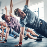 Class working on best shoulder exercises with plank pose