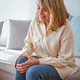 Woman suffering from bone marrow edema, holding knee